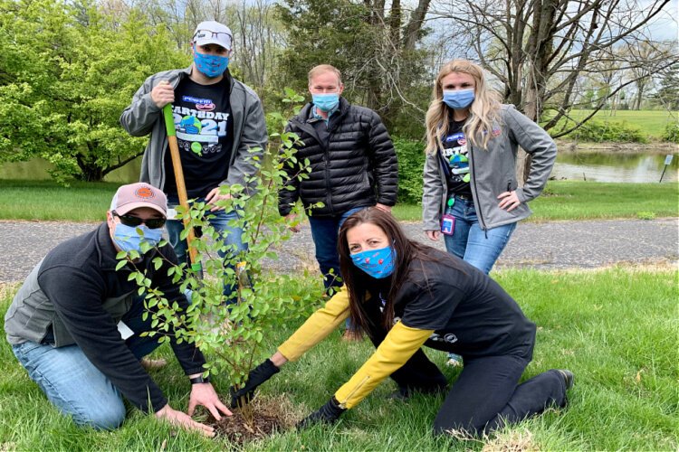 Perfetti Van Melle offers employees opportunities for community engagement and sustainability. Earth Day tree planting with CEO Sylvia Buxton, kneeling. 