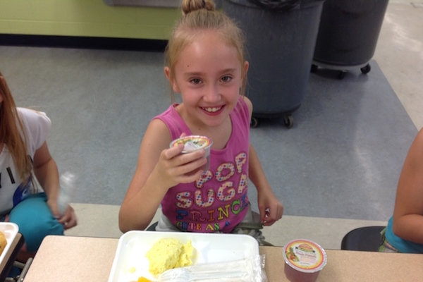 Annabell Roberts shows off her breakfast at UpSpring's Summer 360 camp location at Caywood Elementary in Edgewood
